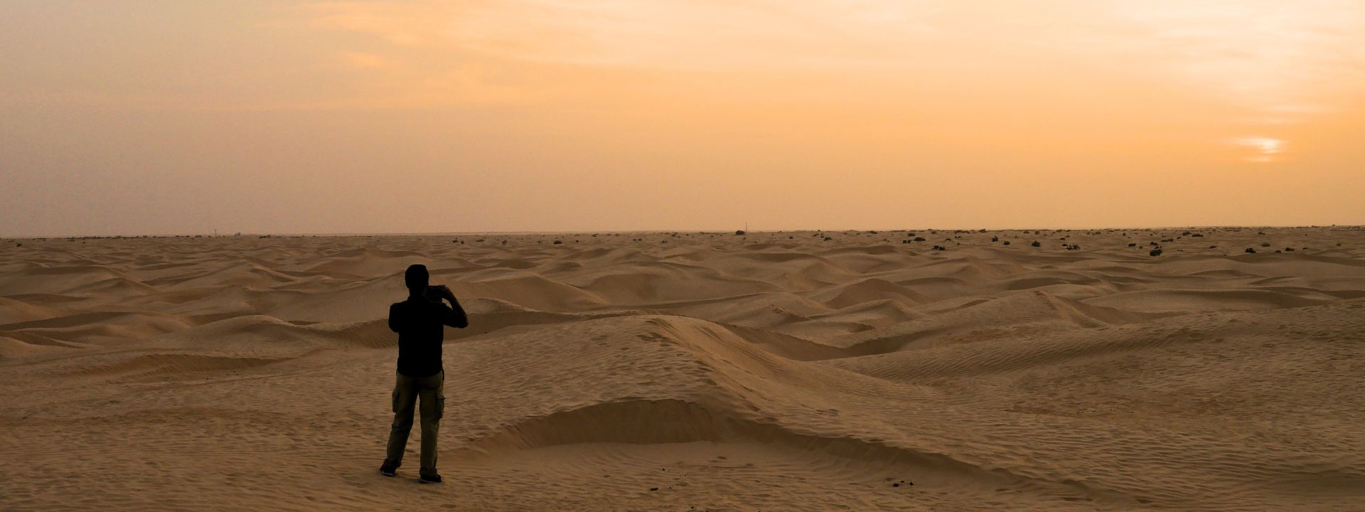 Luke Lythgoe taking photos across sand dunes in the Sahara